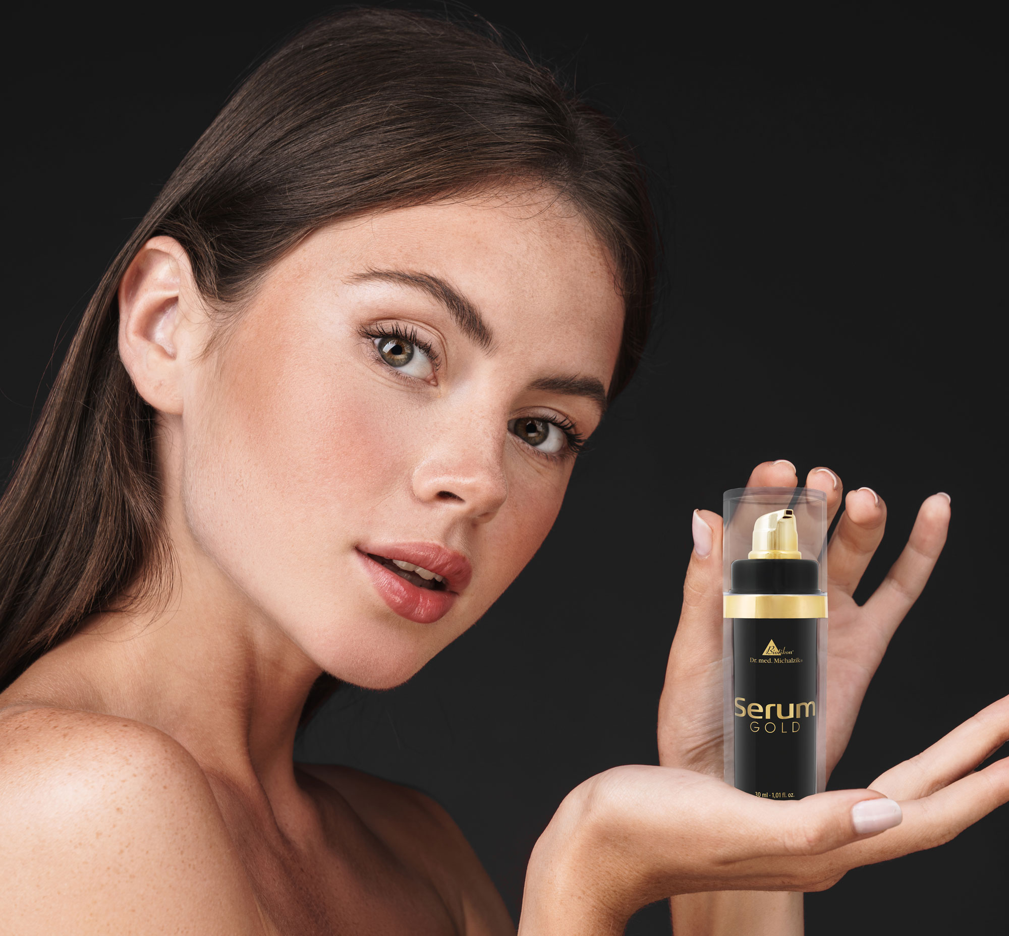 Gesichtsserum in einer eleganten Pumpflasche, 30 ml, schwarz-goldene Verpackung, in der Hand einer Frau präsentiert.